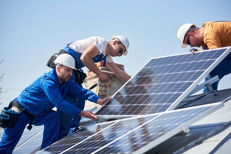 Solar equipment installation team carrying solar panel